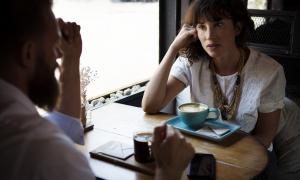 Mannund Frau unterhalten sich am Tisch