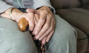 Hände einer älteren Person mit Gehstock 