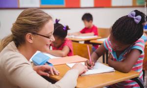 Hausaufgabenhilfe: Betreuerin und Kinder mit Migrationshintergrund.