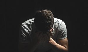 Mann versteckt Kopf in Händen