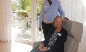 Leiterin der Einrichtung Sabine Wittmann in einem Ruhesessel eines der Gästezimmer mit Stephan Powils, der das stationäre Hospiz in Nürnberg-Mögeldorf leitet