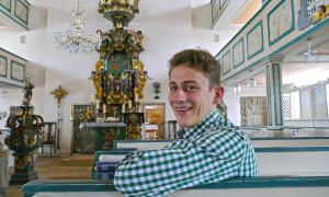 Ein Mann im karierten Hemd in einer Kirche