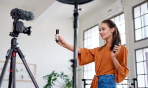 Eine Frau steht vor einer Kamera und hält ein Produkt in die Linse. Was Influencer halt so machen