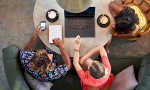 Junge Menschen an einem Tisch mit Laptop und Milchkaffee