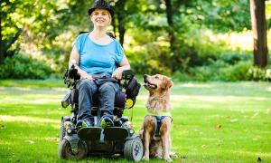 Eine Frau im Rollstuhl mit ihrem Assistenzhund