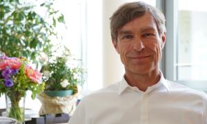 Porträt von Thorsten Nolting. Er hat graue Haare und trägt ein weißes Hemd.