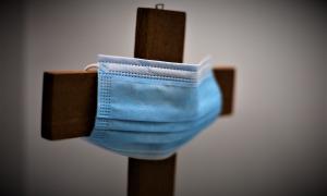 Eine Maske an einem Kreuz