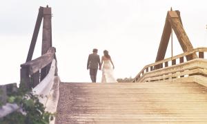 Ein Hochzeitspaar geht über eine Brücke