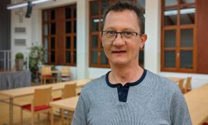 Ein Mann mit einer Brille blickt in die Kamera.