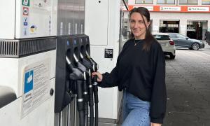 Eine Frau steht an einer Zapfsäule