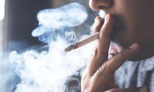 Eine brennende Zigarette im Mund einer Person