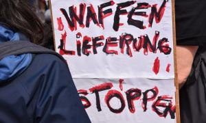 Ein Plakat, auf dem "Waffenlieferung stoppen" steht