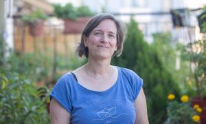 Eine Frau mit hellbraunen Haaren in einem blauen T-Shirt