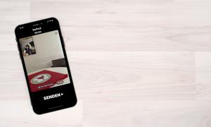 Ein Smartphone liegt auf dem Tisch. Auf dem Display ist die App BeReal geöffnet. 