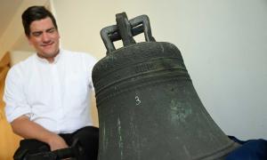 Pfarrer Penzberg mit der historischen Glocke