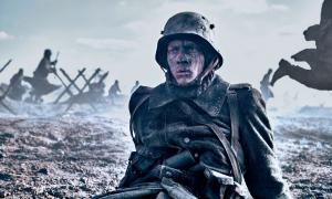 Szene aus dem Film: Paul Bäumer an der Front. Er trägt eine Uniform und einen Helm. Er ist mit Schlamm beschmiert. 