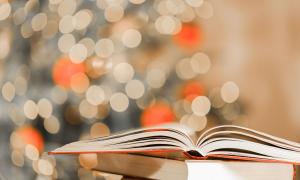 Ein Buch liegt aufgeschlagen auf anderen Büchern
