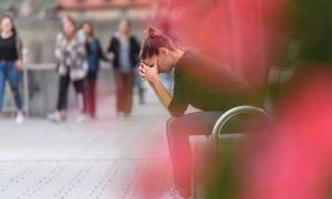 Eine Frau sitzt erschöpft auf einer Bank