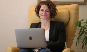 Eine Frau mit einem Laptop auf dem Schoß