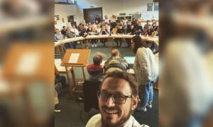 Ein Raum, in dem viele Menschen an einem runden Tisch sitzen