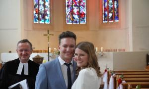 Ein Pfarrer und ein Paar aus Mann und Frau