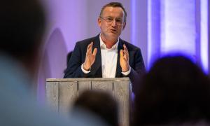 Ein Mann steht am Rednerpult und hält eine Rede