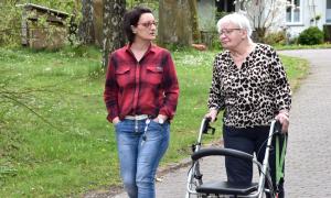 Zwei Frauen, eine mit Rollator