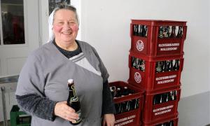 Eine Frau in Nonnentracht vor einem Stapel Bierkästen