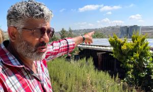 Von Siedlungen umgeben, die eigene Solaranlage vom Abriss bedroht: Daoud Nassar (52) deutet auf den Kibbuz Rosh Tzurim ("Felsenspitze" oder "Felsenkopf") im Südwesten des Hügels seiner Familie.