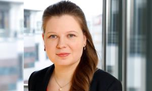 Frau Ende dreißig blickt frontal in die Kamera. Sie hat einen langen Zopf, der seitlich abfällt.