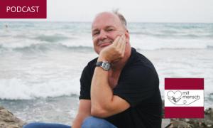 Ein Mann sitzt am Meer