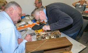 Ehrenamtliches Team des Repair-Cafes in Wendlingen am Neckar (Kreis Esslingen) beim Reparieren eines alten Radios 