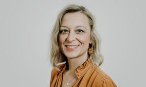 Eine Frau mit blonden Haaren, sie lächelt