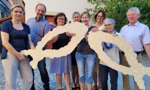 Gruppe von Menschen halten zwei Fische in Ihren Händen. 