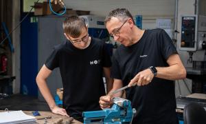 Ausbildungsleiter Steffen Uhr vom Metallverarbeitungsunternehmen Franz Hof im mittelhessischen Haiger zeigt seinem Azubi Tobias Keil, wie man Werkstuecke feilt