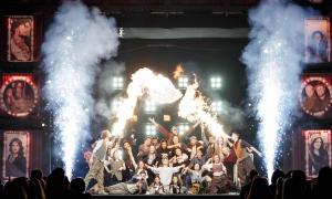 Menschen auf einer großen Bühne, mit Pyroeffekten