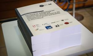 Die gedruckte ForuM-Studie liegt während der Pressekonferenz auf einem Tisch.