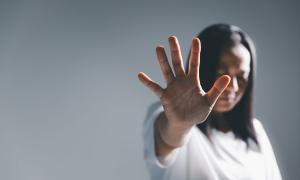 Eine Frau hält ihre Hand abwehrend nach vorne