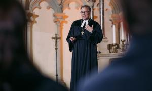 Ein Mann im Talar mit einem Bischofskreuz um den Hals