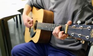 Mann spielt Gitarre. 