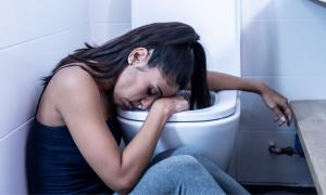 Eine Frau sitzt neben der Toilettenschüssel