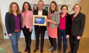 Fünf Frauen und ein Mann stehen in einer Reihe