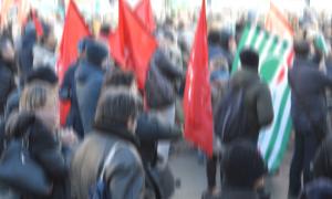 Menschen demonstrieren mit roten Fahnen