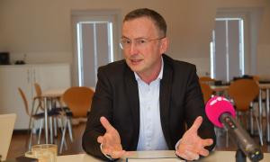 Ein Mann im Jacket, darunter ein weißes Hemd