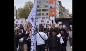 Menschen bei einer Demo mit Fahnen und Schildern