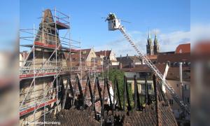 Eine abgebrannte Kirche mit Gerüst, davor ein Kran
