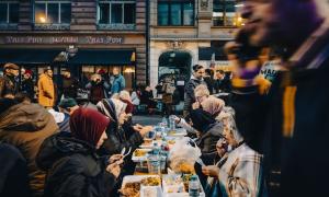 Menschen essen an Tischen, die auf der Straße stehen