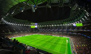 Ein Fußballstadion, grüner Rasen, es ist dunkel, nur der Platz leuchtet im Flutlicht