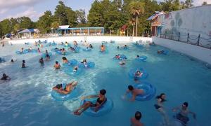 Ein Schwimmbecken voll mit Kindern, viele haben einen blauen Schwimmreifen
