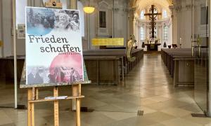 Ein Plakat ist an der geöffneten Tür einer Kirche zu sehen